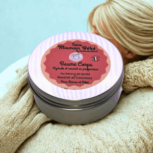 Baume Corps riche hypoallergénique 150 ml dans un pot métallique, étiquette rose sur capuchon, entouré de laine beige.