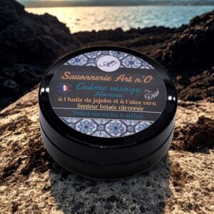 Pot de crème hydratante visage homme au jojoba et aloe vera, parfum citronné, peau normale à sèche, présentation marbrée sur fond rocheux.