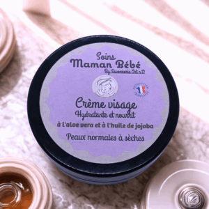 Crème visage hypoallergénique Bio Aloe Vera et Jojoba, pot rond violet, label texte “Soins Maman Bébé” pour peaux normales à sèches, hydratante.