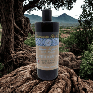 Bouteille de savon liquide noir sur rocher, étiquette beige et bleue indiquant “Savon Liquide” et “Petit Karité”, parfum naturel, huile de karité.