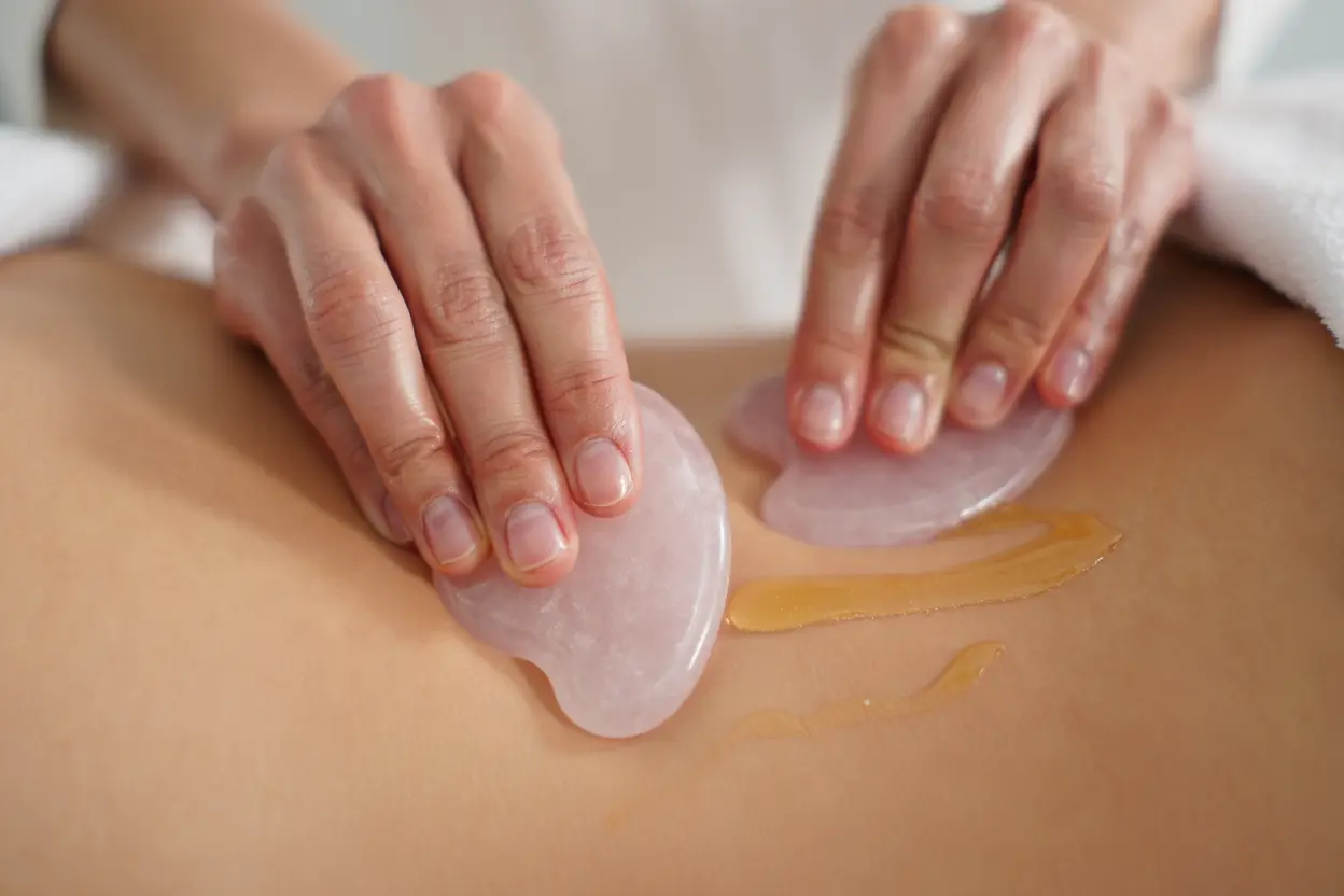 Massage anti-cellulite avec gua sha en quartz rose