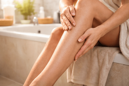 Peau sèche et fragile au bain. Femme dans une salle de bain assise sur une baignoire qui montre ses jambes